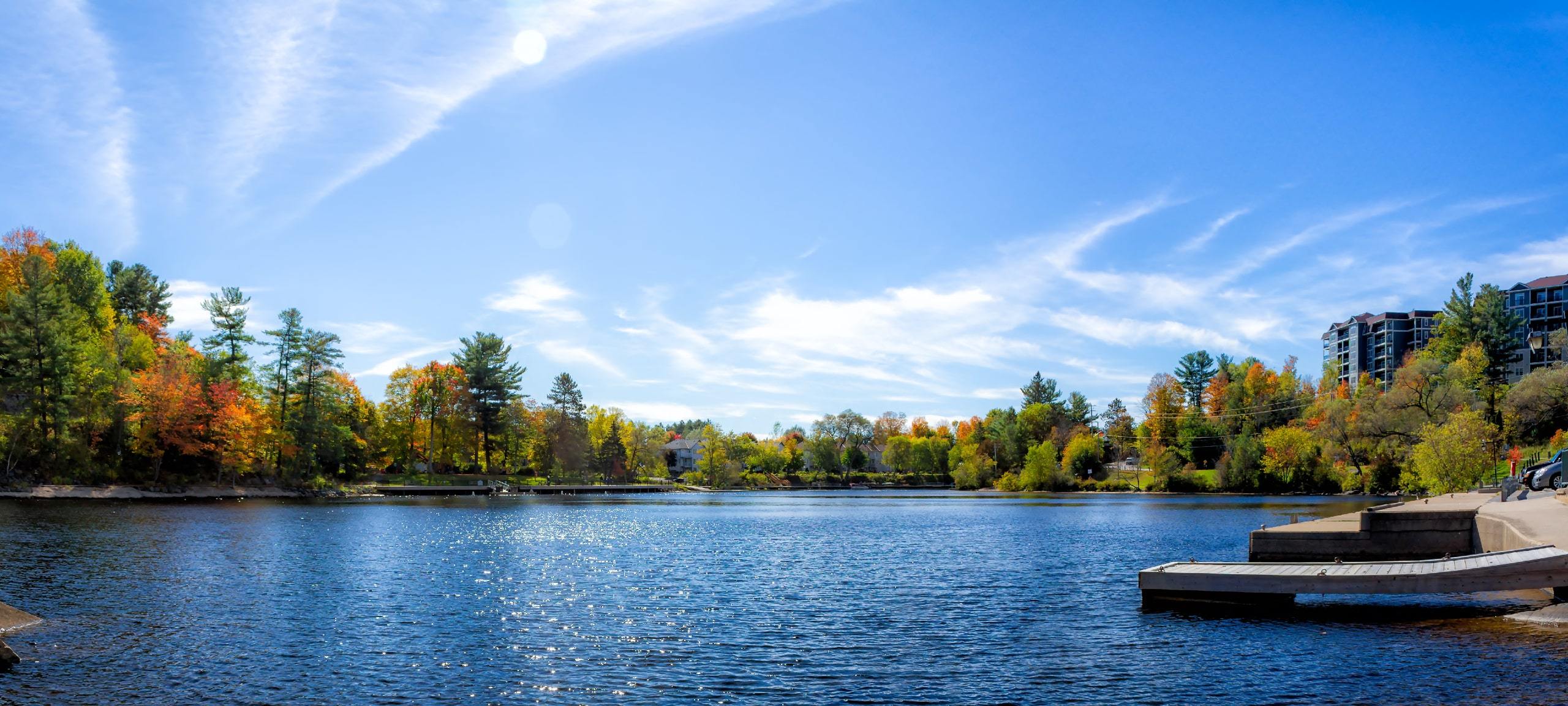 View of lake, trees, and condos on waterfront in Bracebridge, ON